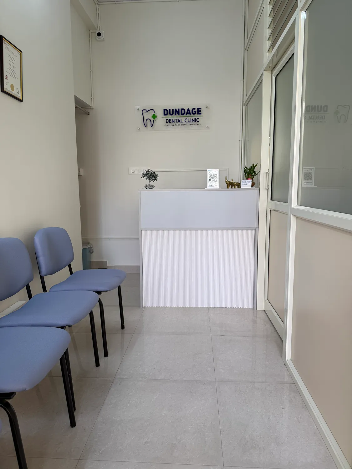 White reception counter and blue waiting chairs inside the clinic